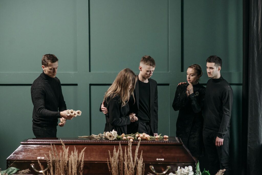 Family mourns together in solemnity at a funeral indoors.